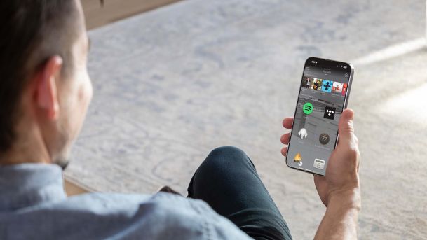 Man looking at phone with Control4 interface