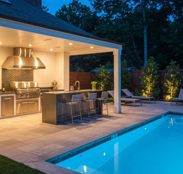 modern outdoor kitchen with a pool nearby